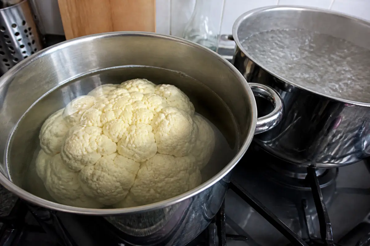 Chou-fleur en cuisson, immersion dans eau chaude sur cuisinière en inox, préparation idéale.