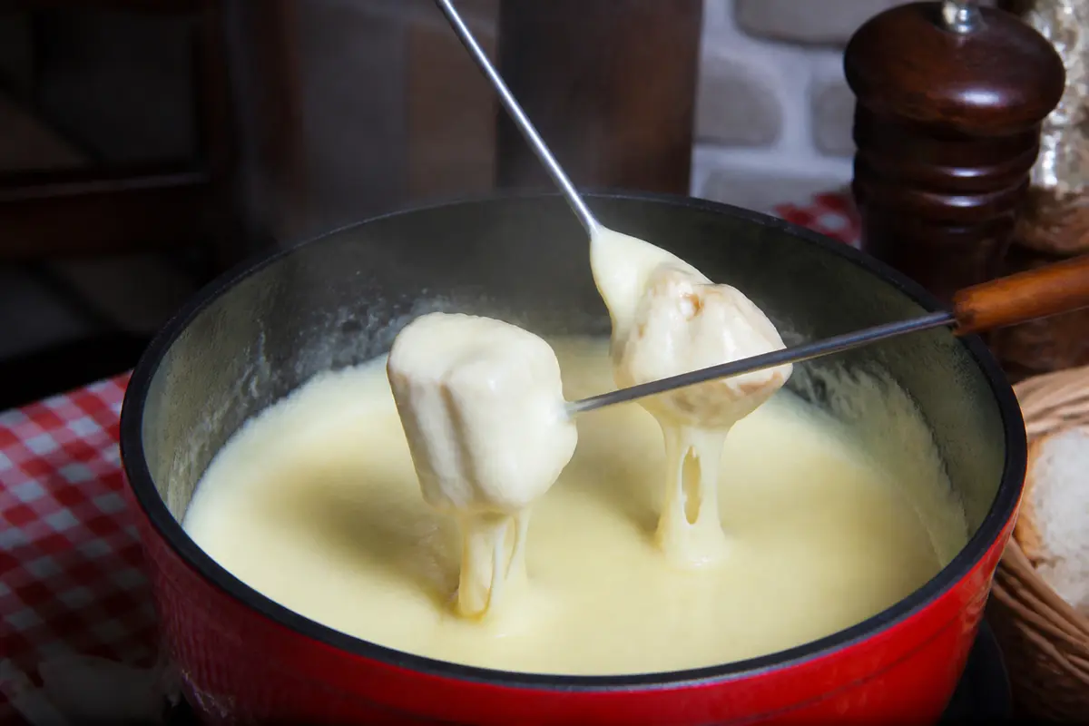 Assiettes de pain plongées dans une fondue savoyarde sans alcool crémeuse et délicieuse