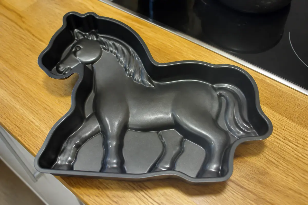 Moule à gâteau en forme de cheval sur plan de travail en bois