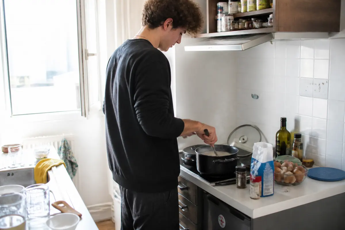 Un étudiant cuisine un plat simple dans une petite cuisine étudiante recettes faciles